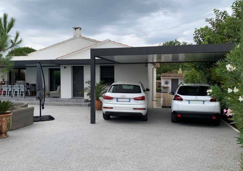 Maison moderne avec deux voitures garées.