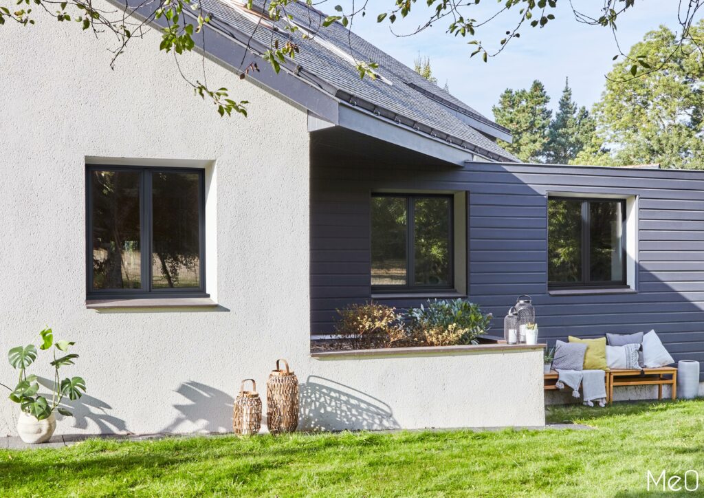 Maison moderne avec jardin ombragé, après-midi ensoleillé.