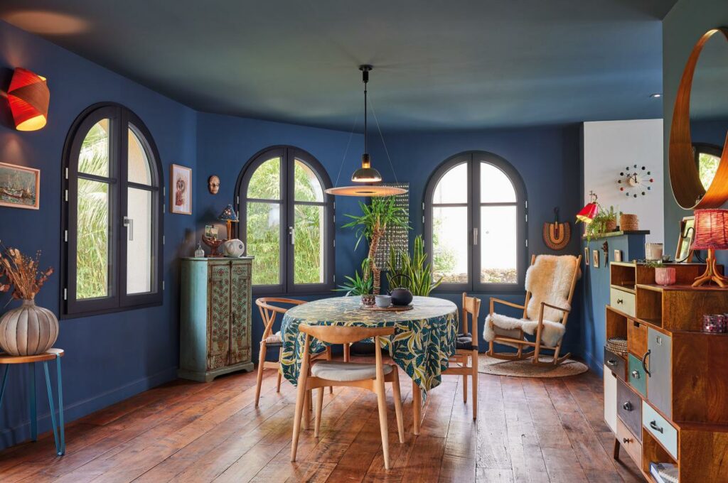 Salle à manger colorée avec fenêtres arrondies.