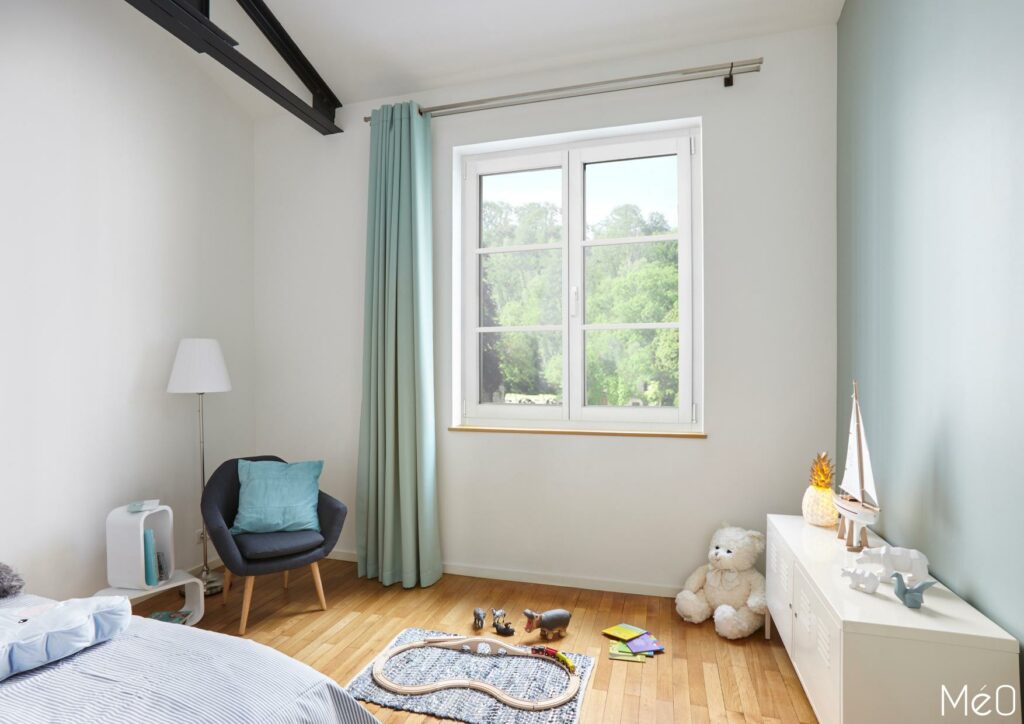 Chambre d'enfant lumineuse avec jouets au sol.