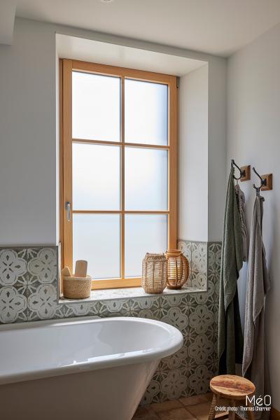 Salle de bain lumineuse avec fenêtre en bois.